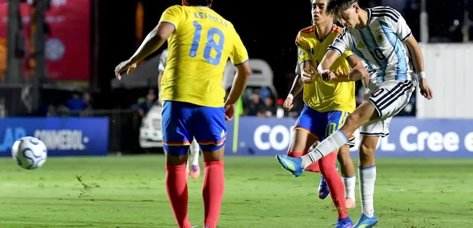 Jugador argentino disparando mientras es marcado por rivales