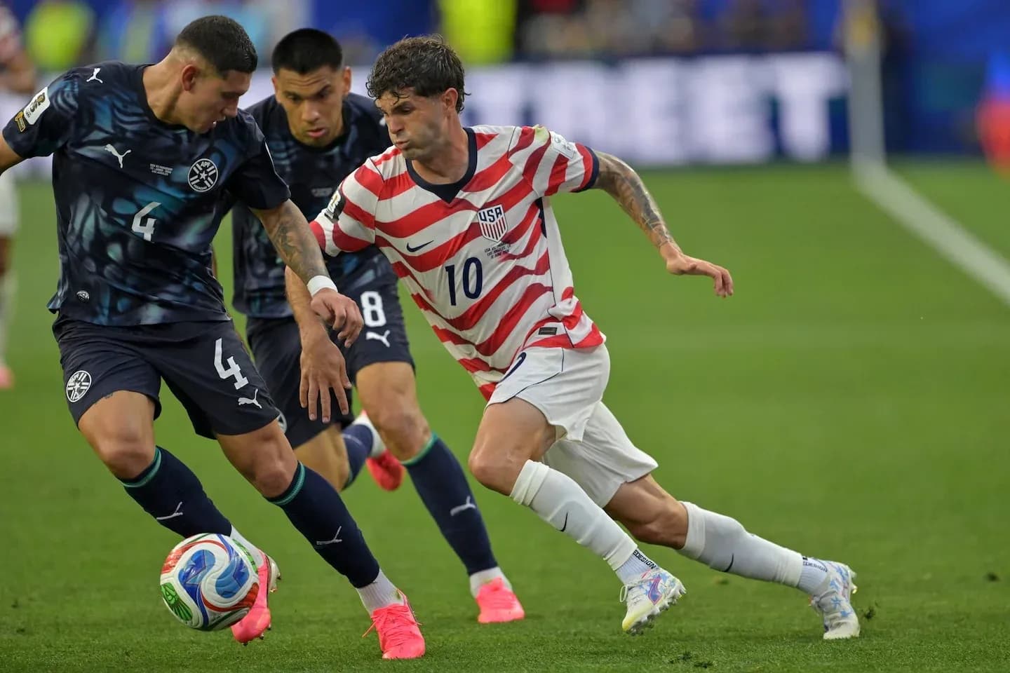 Christian Pulisic dribbling past defenders during match