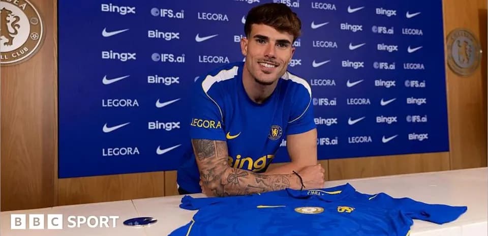 Jugador posando con camiseta de Chelsea en rueda de prensa