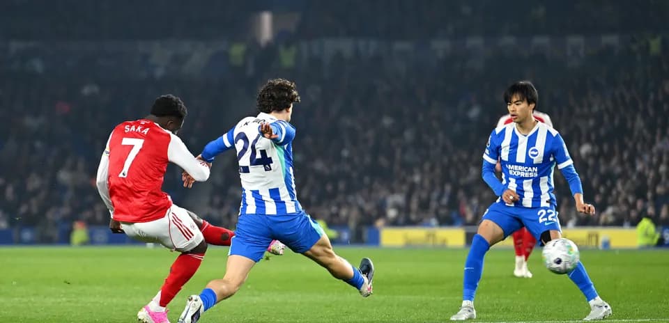 Saka dispara mientras es defendido por jugadores
