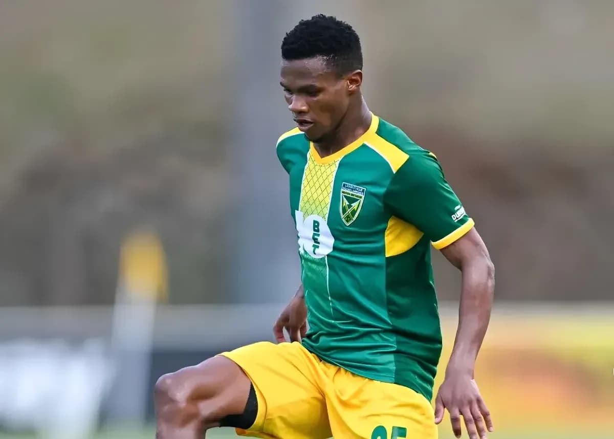 Jugador de fútbol con uniforme verde y amarillo en acción