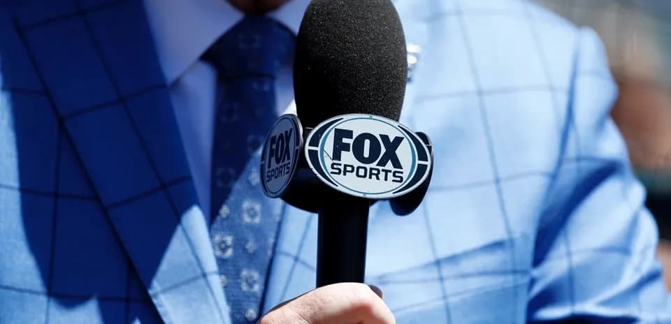 Mic with FOX Sports logo held by a person