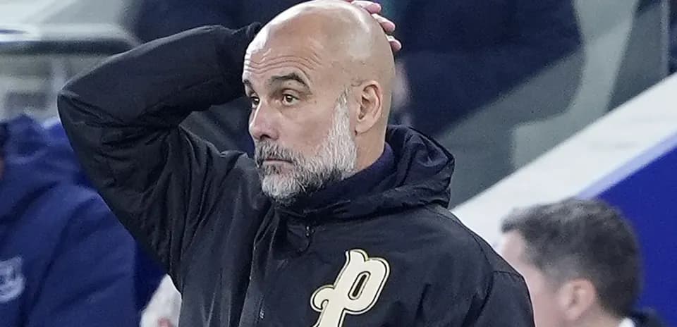 Entrenador con chaqueta negra observando el partido