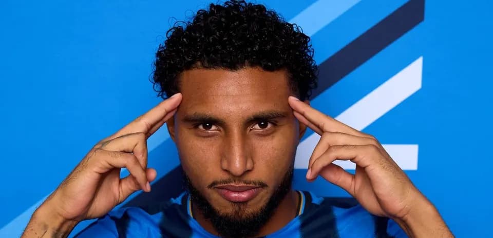 Jugador posando con fondo azul y gesto pensativo
