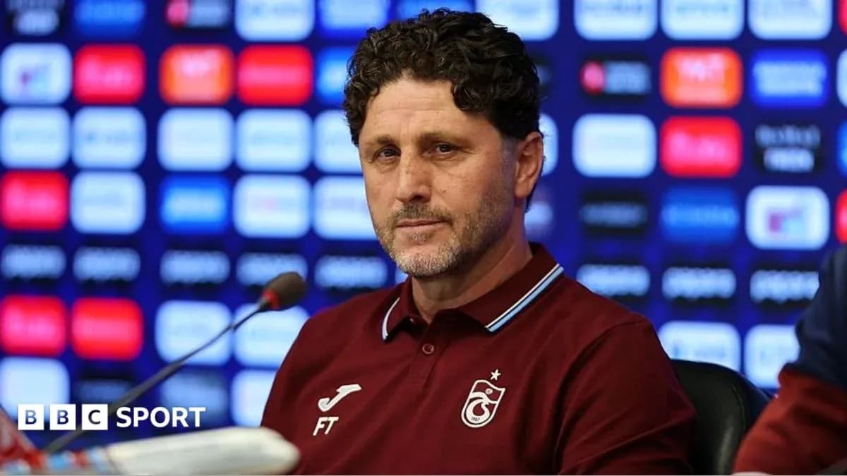 Entrenador en conferencia de prensa con fondo de logos