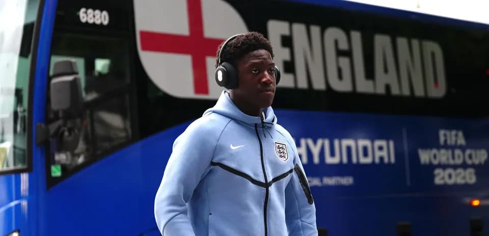 Jugador caminando junto a autobús de Inglaterra
