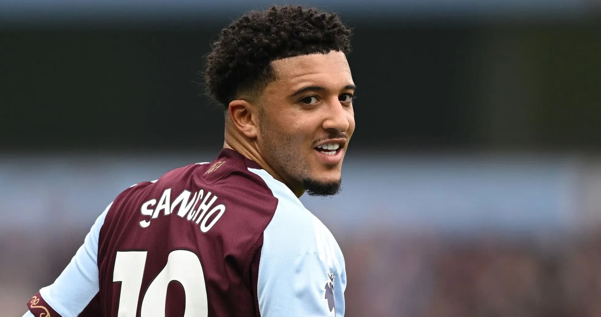 Jugador con camiseta de Aston Villa sonriendo a cámara
