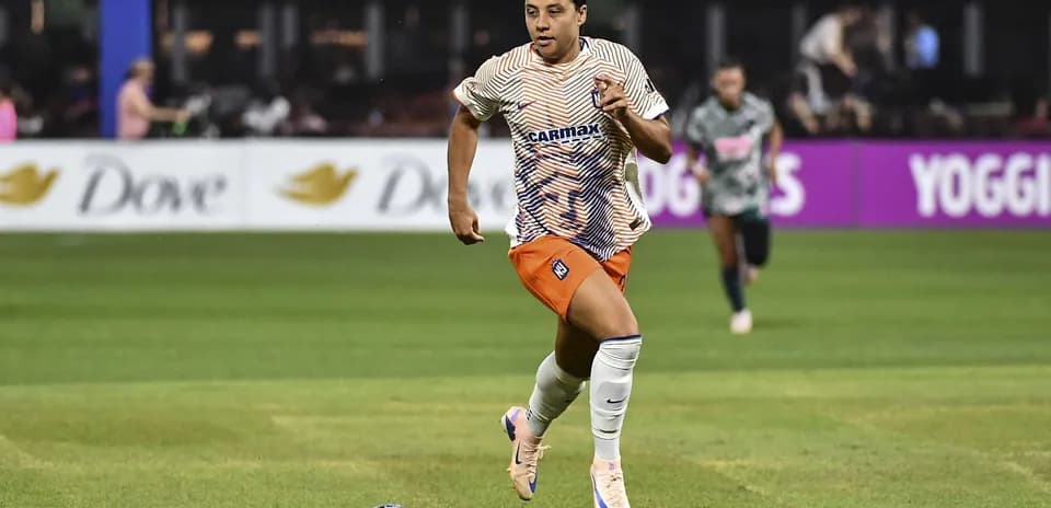 Jugador corriendo con balón durante un partido