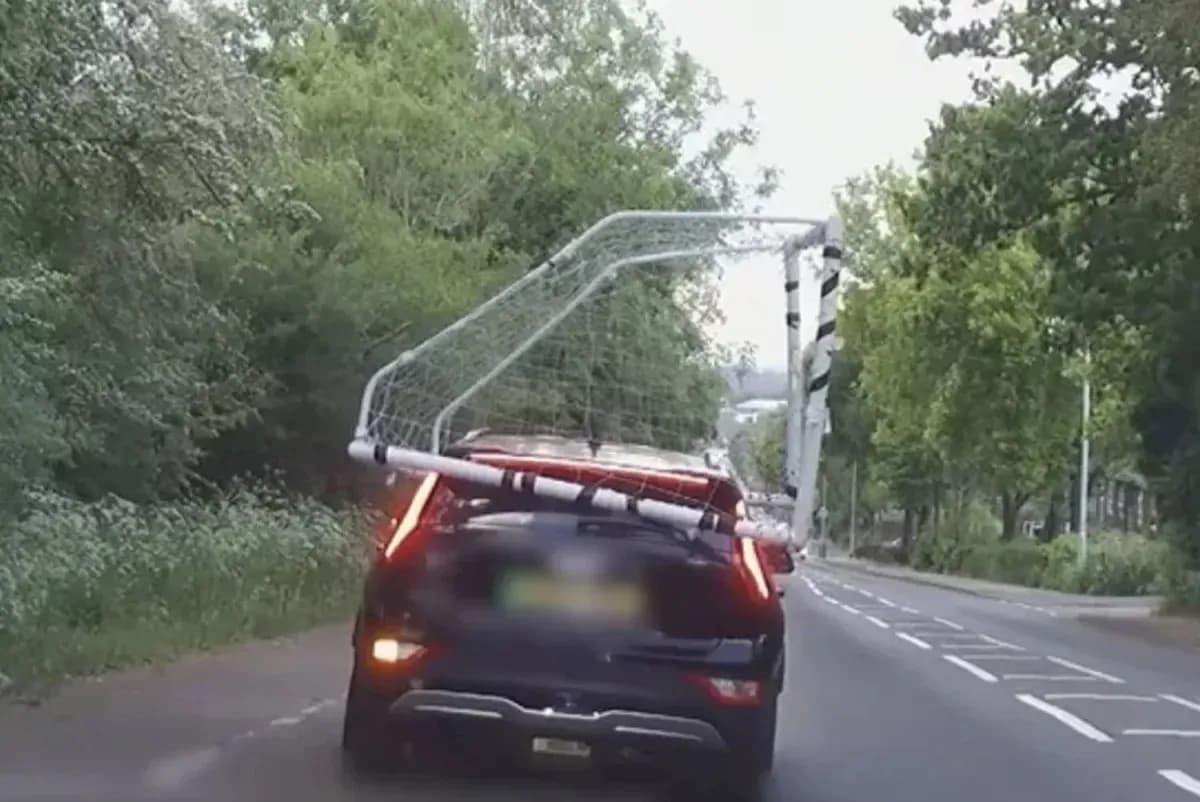 Coche transportando una portería de fútbol en la carretera