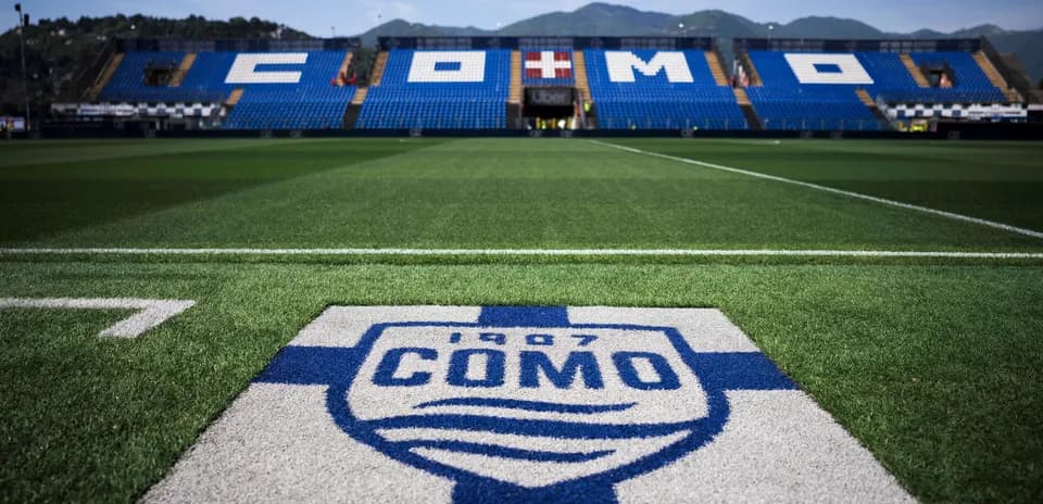 Campo de fútbol con logo de Como 1907 visible
