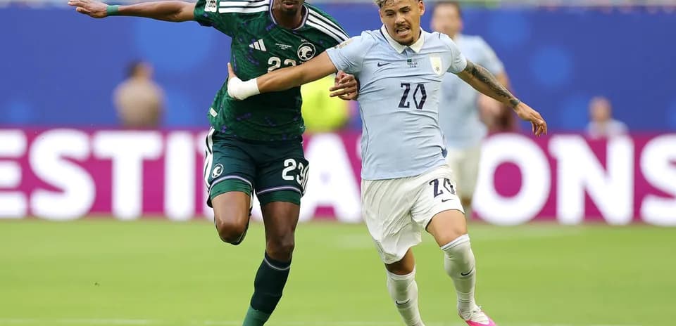 Jugador de Arabia Saudita persigue a jugador uruguayo