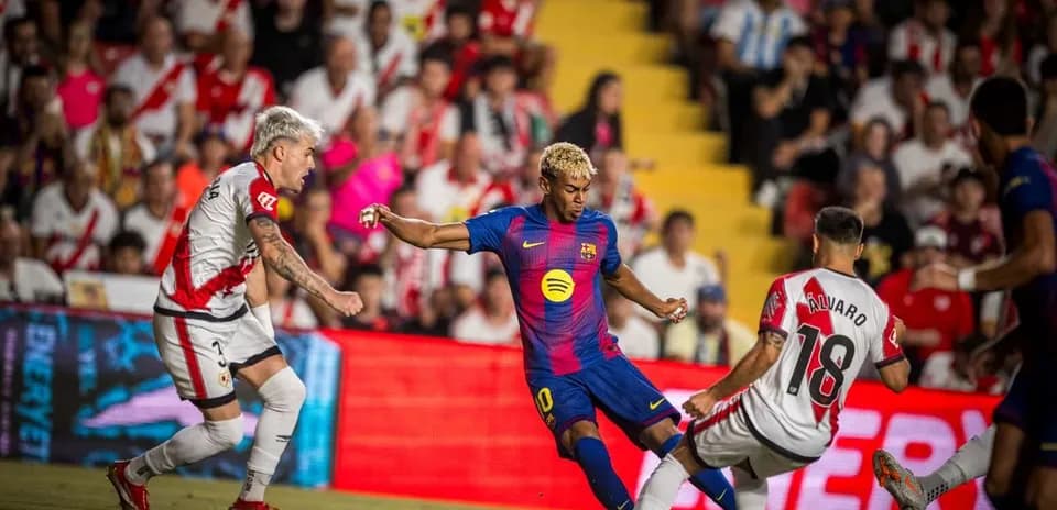 Jugador de Barcelona driblando a defensor de Rayo Vallecano