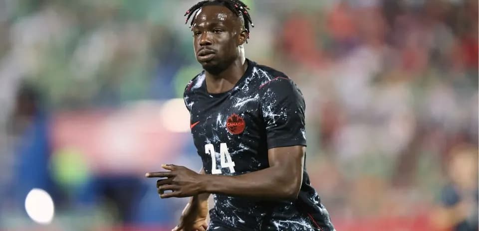 Jugador de Canadá corriendo en el campo de fútbol