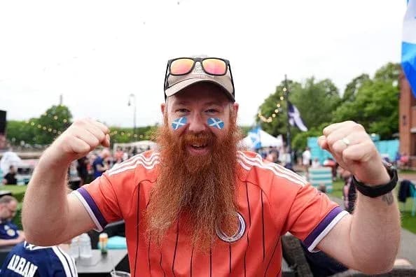 A fan celebrating with painted face and jersey