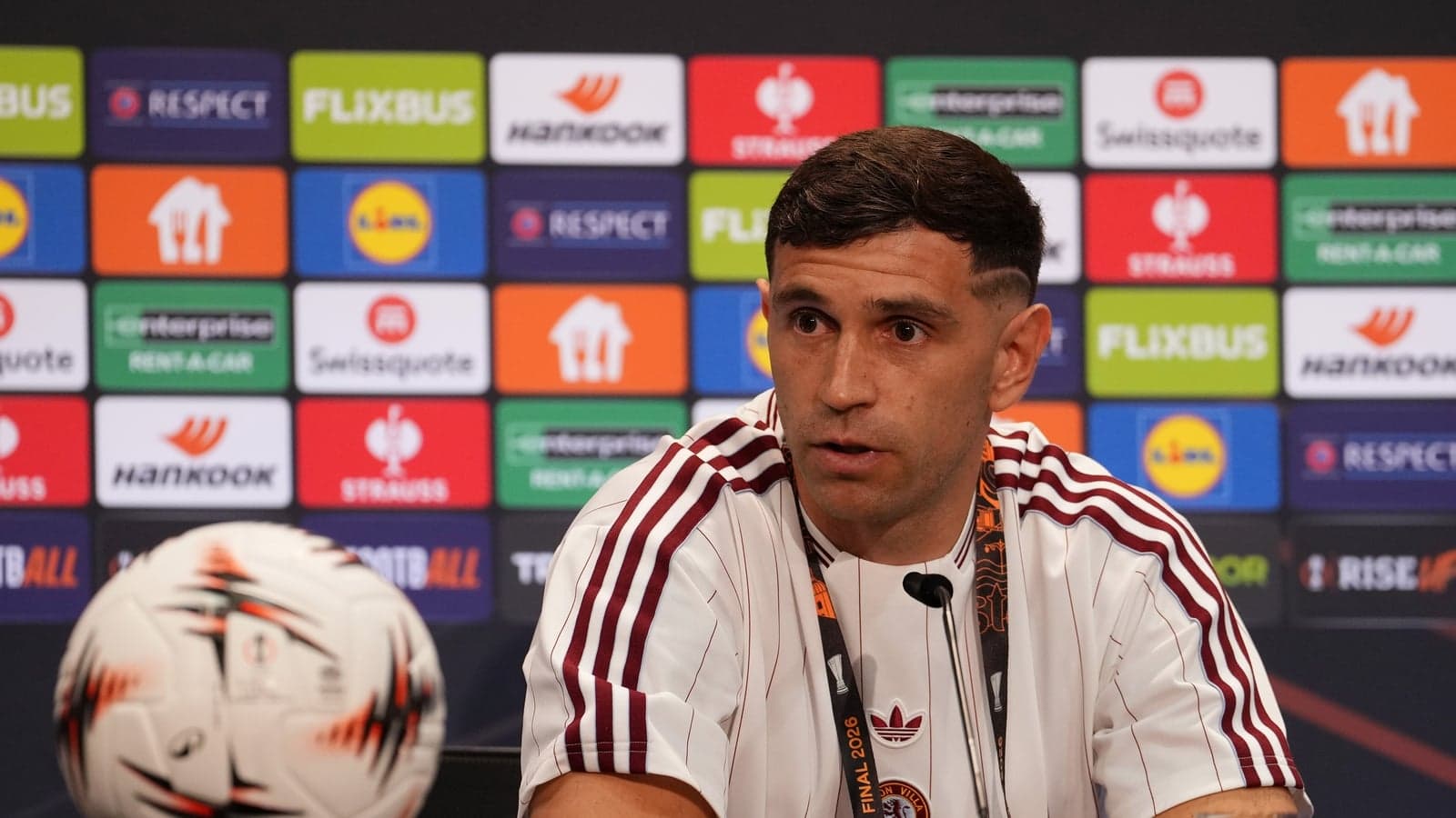 Jugador en conferencia de prensa con balón frente a él