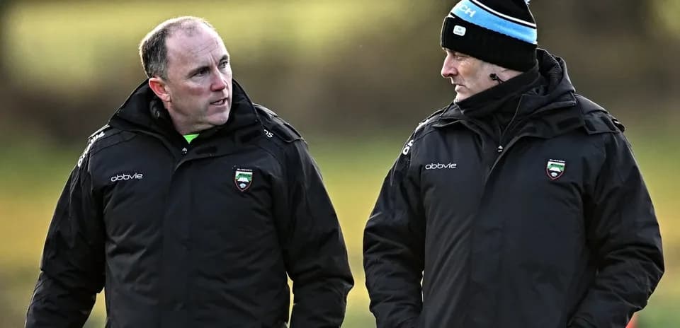Entrenadores conversando en un campo de entrenamiento