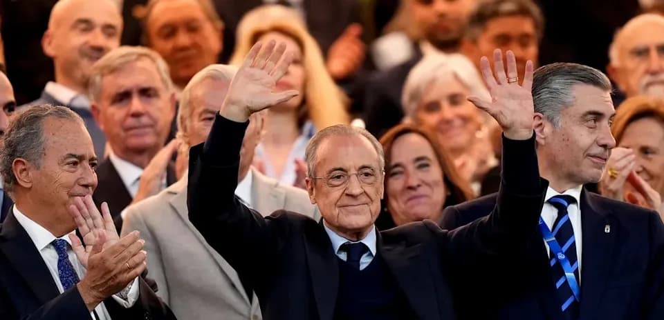 Person saludando en un evento con asistentes aplaudiendo