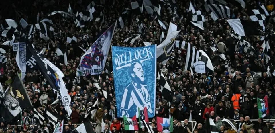 Aficionados con banderas y pancartas en el estadio