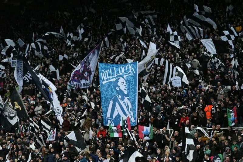 Aficionados con banderas y pancartas en el estadio