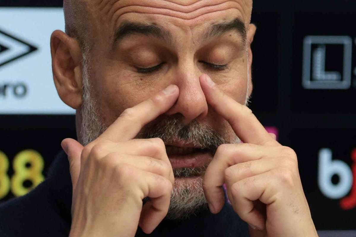 Entrenador tocándose la cara durante conferencia de prensa