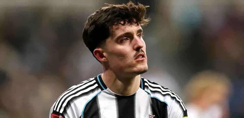 Jugador de Newcastle con camiseta de rayas en el campo