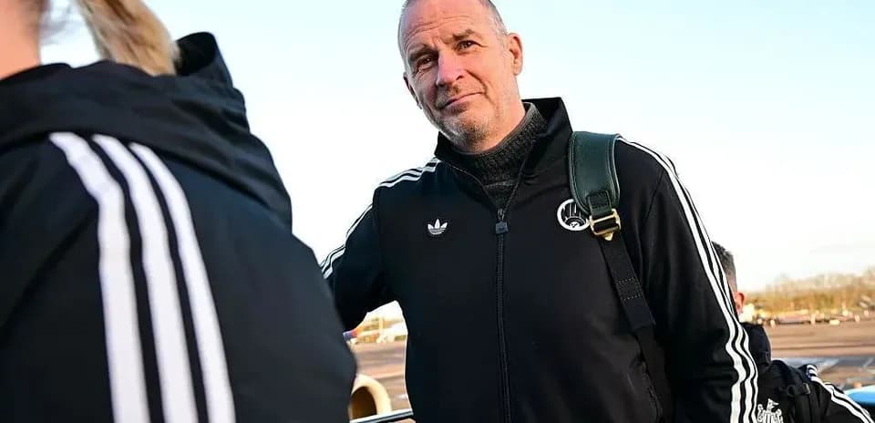 Entrenador con chaqueta negra en el aeropuerto