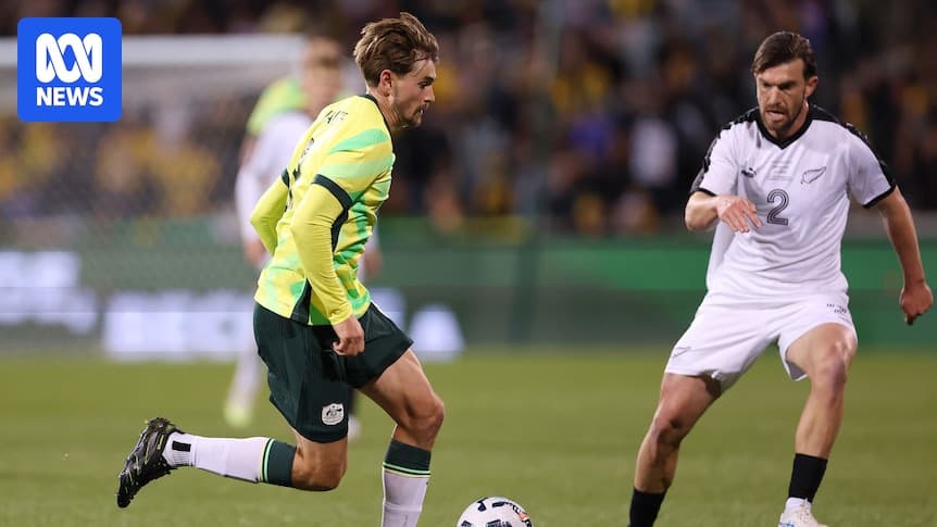 Jugador australiano driblando frente a defensor neozelandés