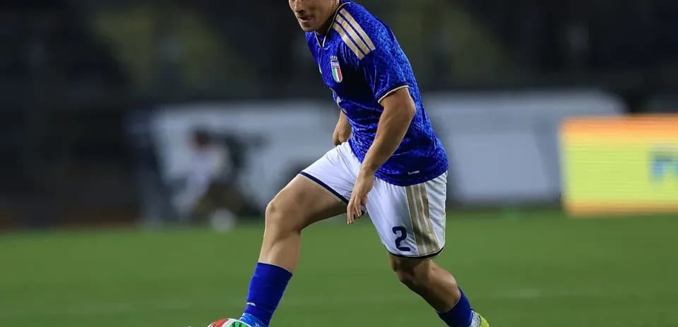 Jugador con camiseta azul corriendo con el balón