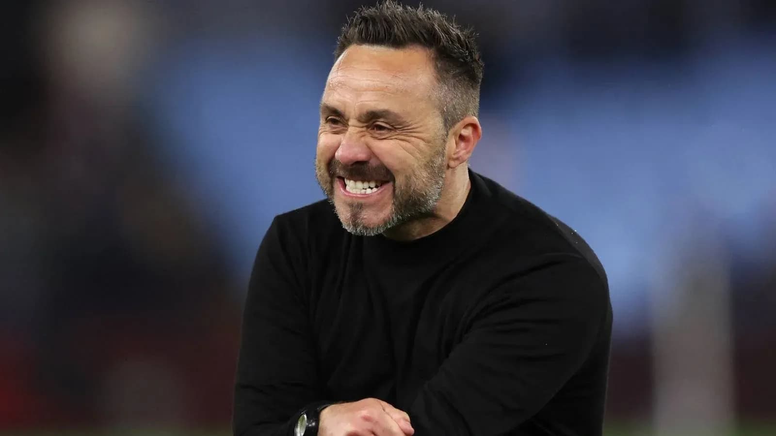 Entrenador sonriente en el campo durante un partido