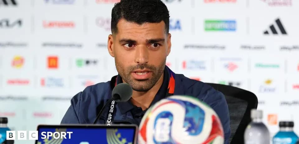 Jugador hablando en conferencia de prensa con balón
