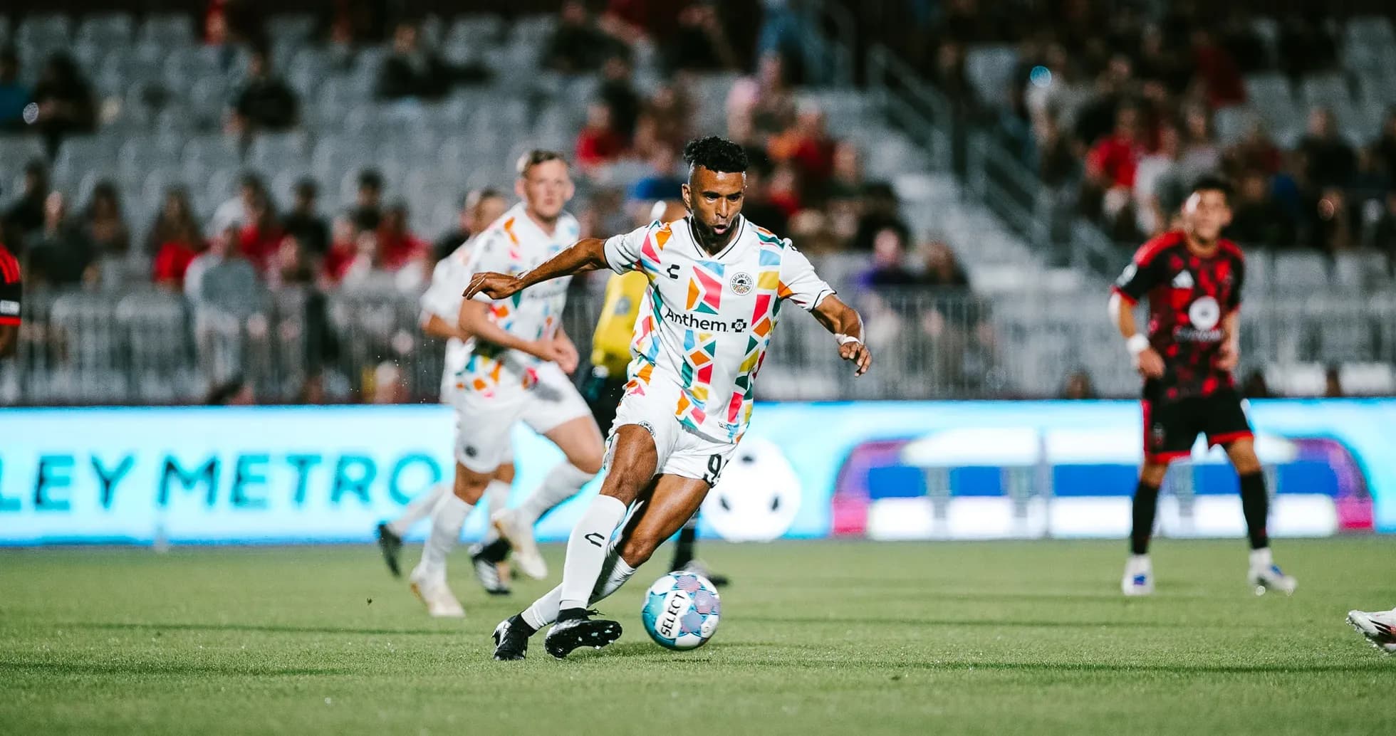 Jugador corriendo con el balón en el partido