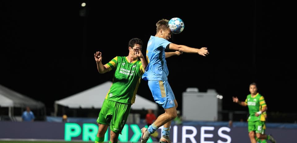 Jugador saltando por el balón en el partido
