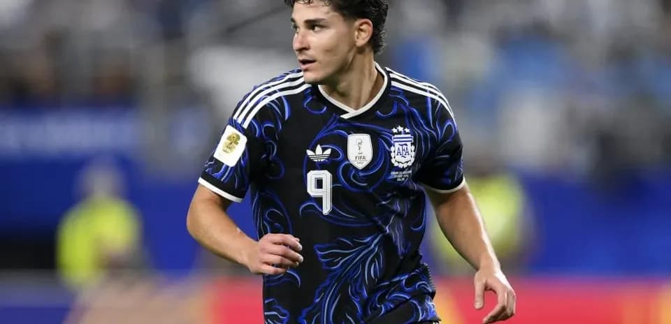 Jugador argentino corriendo en el campo de fútbol