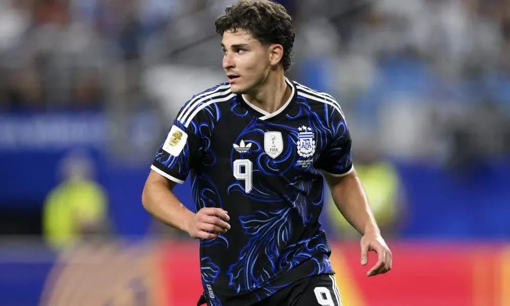 Jugador argentino corriendo en el campo de fútbol