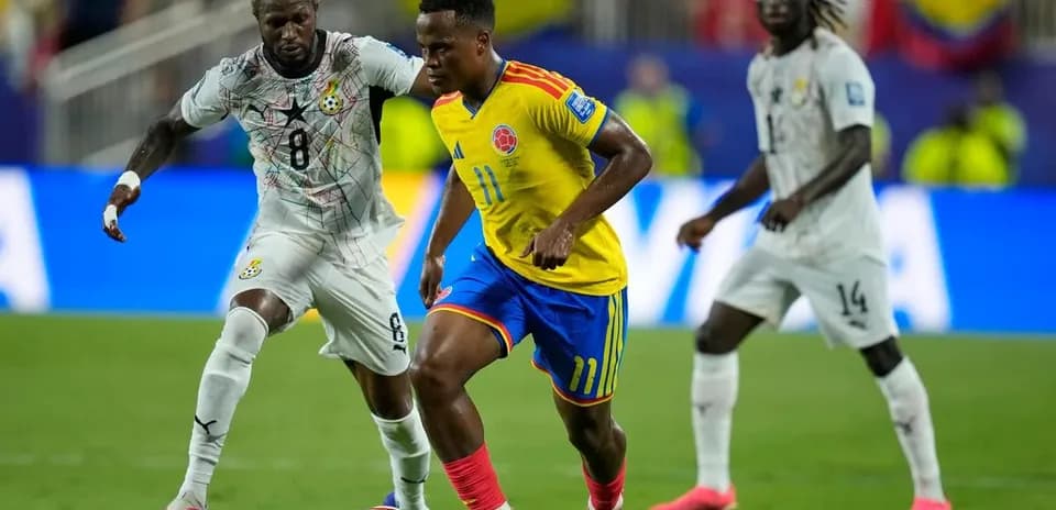 Jugador colombiano driblando a oponente ghanés en partido
