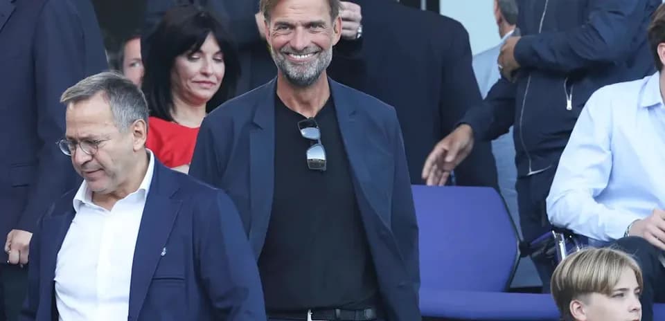 Entrenador sonriendo en evento deportivo con otros asistentes