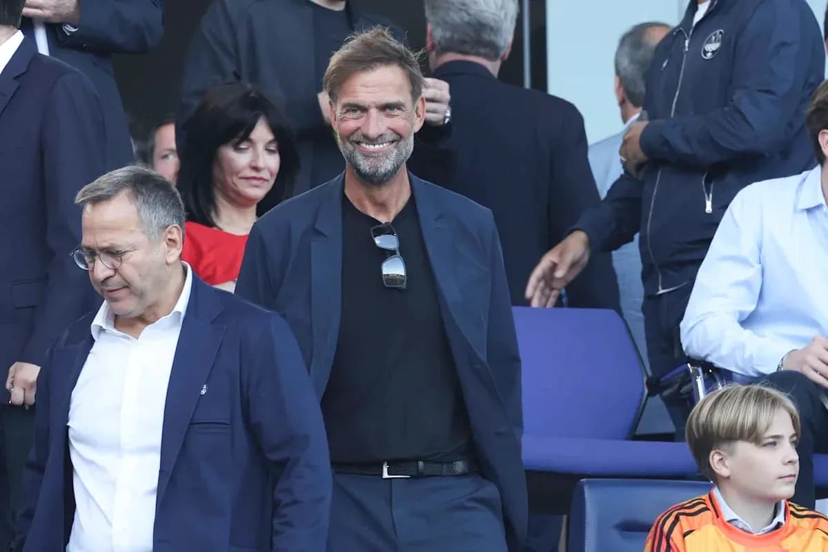 Entrenador sonriendo en evento deportivo con otros asistentes