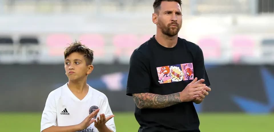 Lionel Messi y niño aplaudiendo en el campo