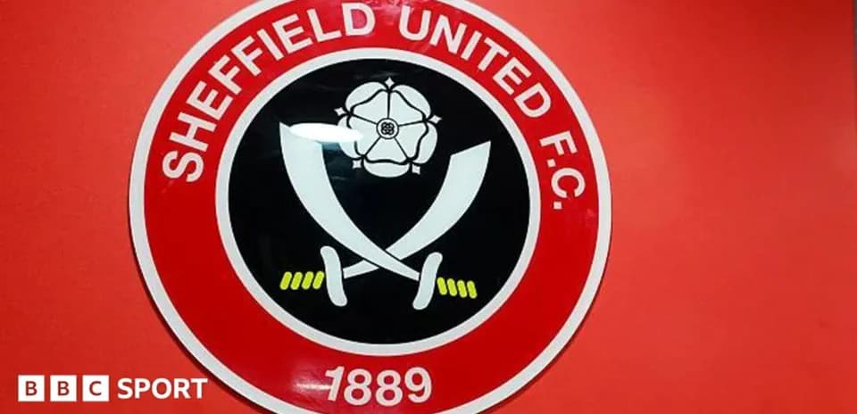 Escudo del Sheffield United F.C. en pared roja