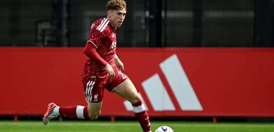 Jugador de Liverpool corriendo tras el balón en campo