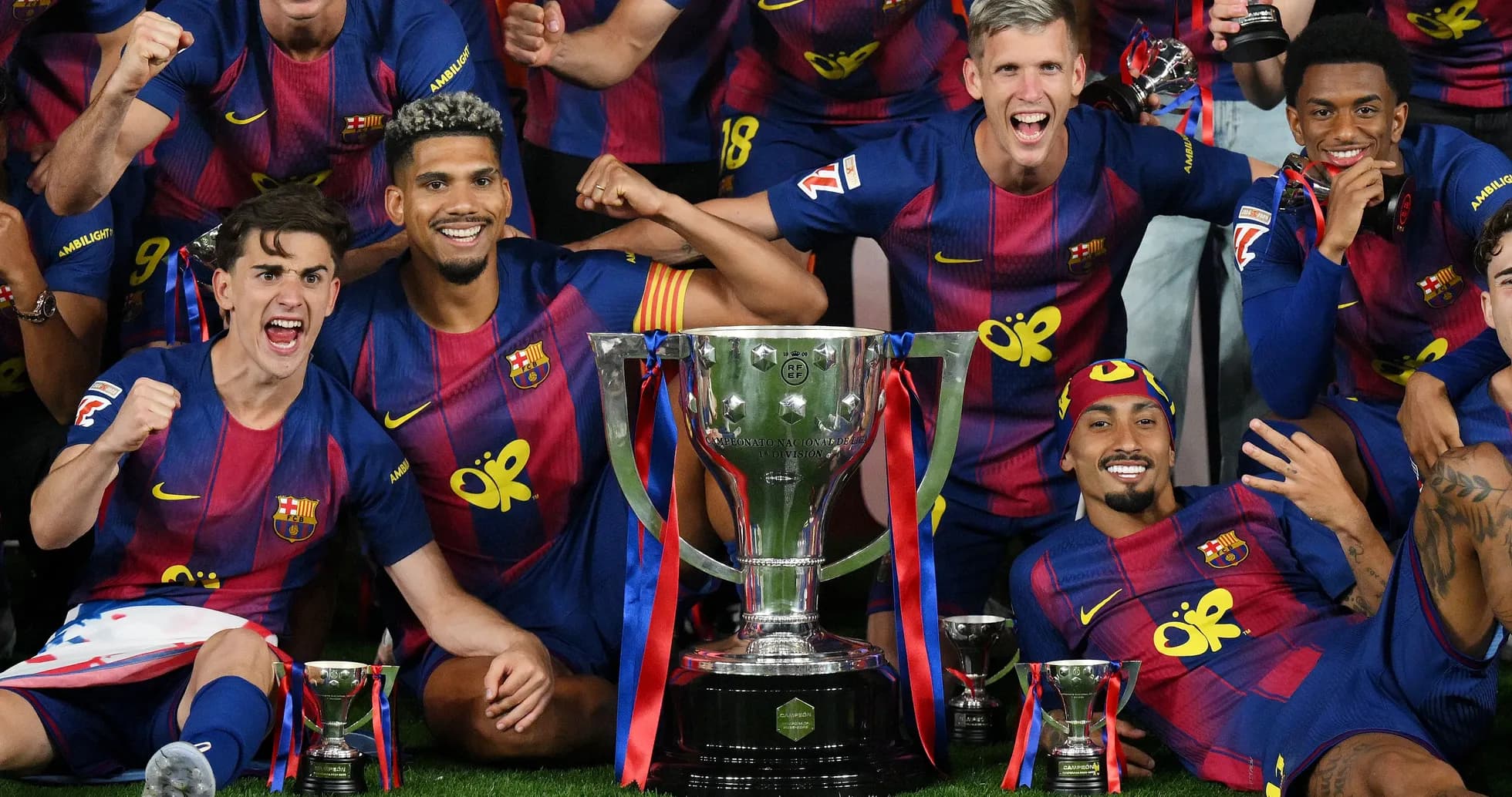 Jugadores del FC Barcelona celebrando con trofeos
