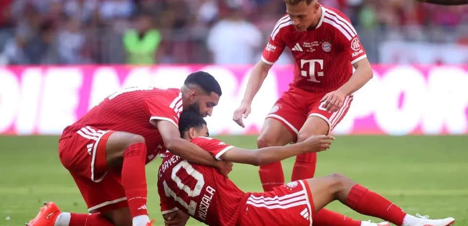 Jugadores de Bayern Múnich ayudando a Musiala en el suelo