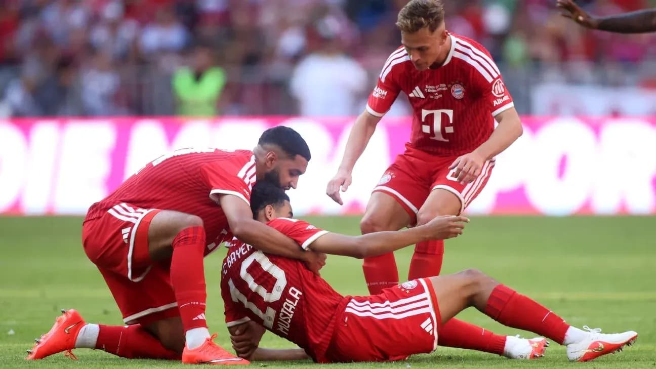 Jugadores de Bayern Múnich ayudando a Musiala en el suelo
