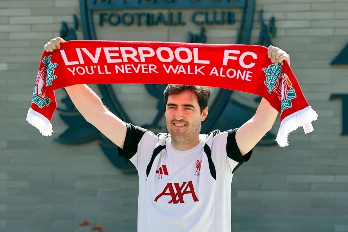Persona sosteniendo una bufanda de Liverpool FC