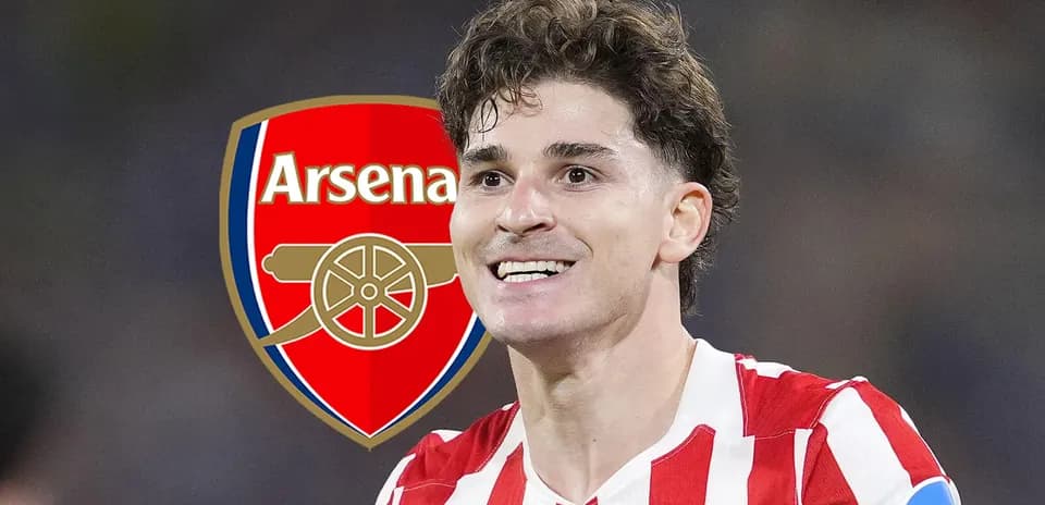 Jugador sonriente frente al logo de Arsenal