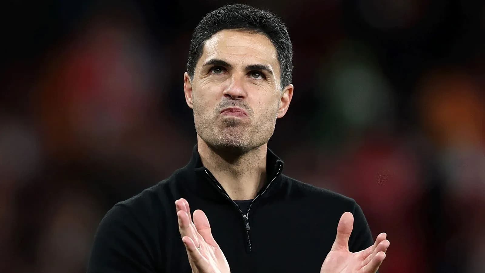 Entrenador aplaudiendo en el campo después del partido