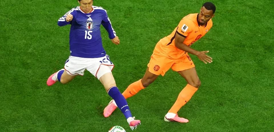 Jugador japonés intentando quitar el balón a jugador neerlandés