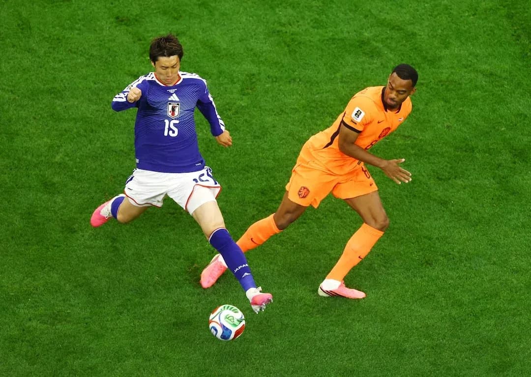 Jugador japonés intentando quitar el balón a jugador neerlandés