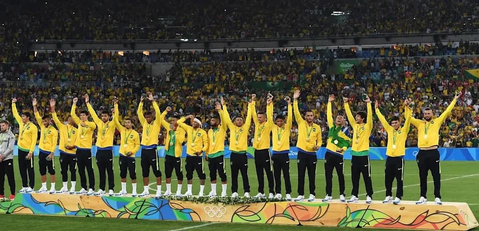 Equipo de fútbol de Brasil celebrando medallas en el podio