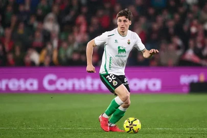 Jugador corriendo con balón en el campo de fútbol
